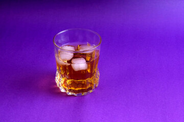 Iced whiskey against purple background. Amber liquid set against a bold purple background. Ideal for use in social media campaigns or alcohol-related advertisements.