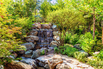 Three -speed small waterfall on a stream in the park