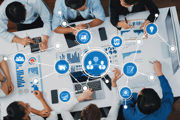 A dynamic business meeting featuring a diverse team analyzing data and collaborating on strategies using modern technology in a contemporary office setting. Amity