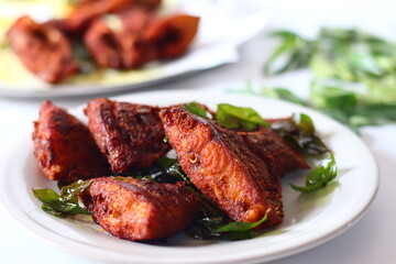 Vietnam pearl spot fish marinated with aromatic spices and fried to golden perfection, garnished with fresh curry leaves