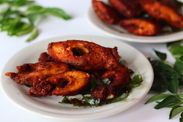 Vietnam pearl spot fish marinated with aromatic spices and fried to golden perfection, garnished with fresh curry leaves