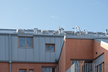 modern residential building features a metal-clad roof with ventilation systems. The structure has...