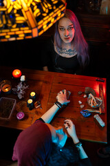 Fortune teller reading tarot cards under tiffany lamp