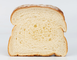 Freshly sliced white bread showing soft texture and golden crust on plain background
