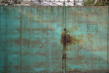 A weathered, likely old, metal door with substantial rust and discoloration
