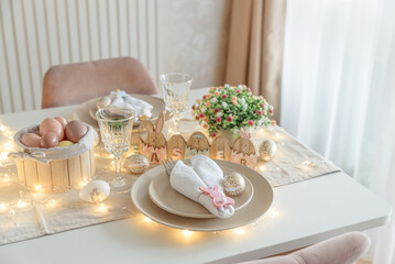 Festive Easter table setting with Easter bunny made from napkin decorated lights. Easter celebration concept