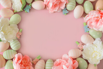 Easter eggs and spring flowers on pastel background. Top view