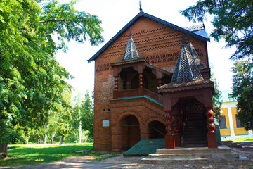 Wooden church with balcony set beside lawn and tall wild trees Rustic building stands in natural...