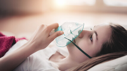 Young woman struggling with virus and asthma using oxygen mask outdoors