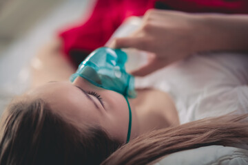Young woman struggling with virus and asthma using oxygen mask outdoors