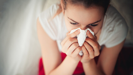 Flu symptoms and allergy reaction – woman sneezing and wiping nose