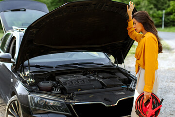 Woman holding battery cable copper wire for repairing broken car by connect battery with red and black line to electric terminal