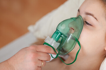 Female patient wearing oxygen mask for breathing support at home