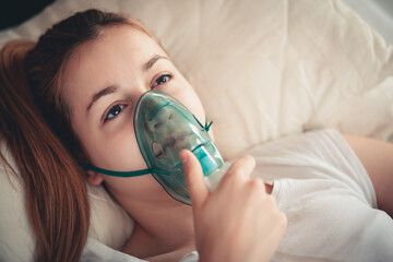 Female patient wearing oxygen mask for breathing support at home