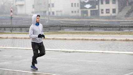 Obraz premium Young man running outdoors in winter