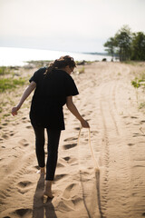 Young Woman Walking on a Sandy Beach