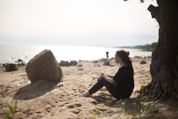 Woman Sitting on the Beach, Gazing Thoughtfully at the Sea