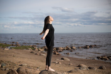 Young Woman Walking on Rocks at the Beach