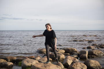 Young Woman Walking on Rocks at the Beach