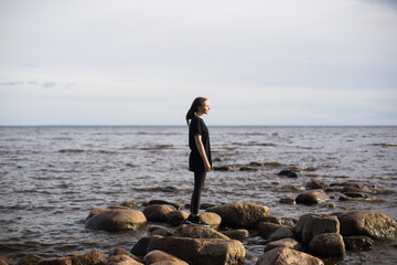 Young Woman Walking on Rocks at the Beach