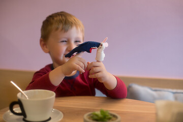 Little Boy Playing with Finger Puppets in a Caf?