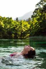 Young Woman Swimming in a Crystal-Clear Alpine Lake