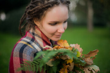Woman with Dreadlocks Holding Autumn Leaves