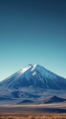 Majestic Snow-Capped Mountain Rises Against Clear Blue Sky in Remote Location