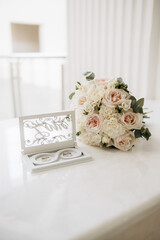 Experience the elegance of wedding details showcasing a beautifully arranged bouquet alongside a stunning presentation of wedding rings, capturing the essence of love, joy, and celebration