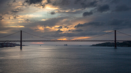 Panoramic Exposure done from a Cruise ship, while arriving at Lisbon at sunrise, of the 25th April Bridge and Tagus River, with Lisbon on the left bank and the Sanctuary of Christ the King, Portugal