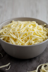 Shredded Mozzarella Cheese in a Bowl, side view.