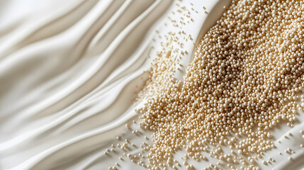 A close-up of light beige sorghum grains resting on a smooth white surface, with subtle natural highlights.