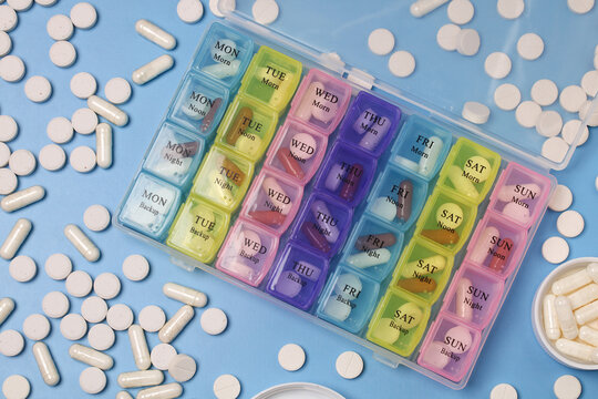 Colorful weekly pill organizer filled with pills and capsules for daily medication. pillbox