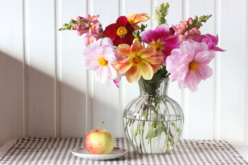 Colorful dahlias and snapdragon bouquet illuminating rustic table setting © Masquerade