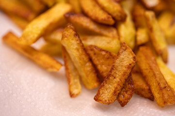 Golden crispy potato wedges sprinkled with sea salt, close-up. Perfect comfort food concept, perfect for fast food menus, advertising and food blogs, selective focus