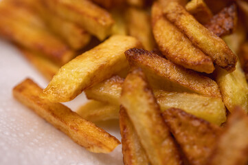 Golden crispy potato wedges sprinkled with sea salt, close-up. Perfect comfort food concept, perfect for fast food menus, advertising and food blogs, selective focus