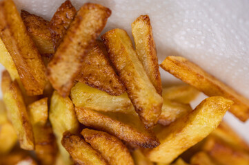 Golden crispy potato wedges sprinkled with sea salt, close-up. Perfect comfort food concept, perfect for fast food menus, advertising and food blogs, selective focus