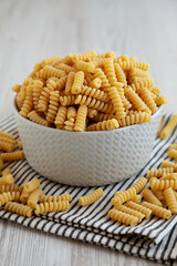 Uncooked Organic Dry Fusilli Pasta in a Bowl, side view.