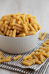 Uncooked Organic Dry Fusilli Pasta in a Bowl, side view.