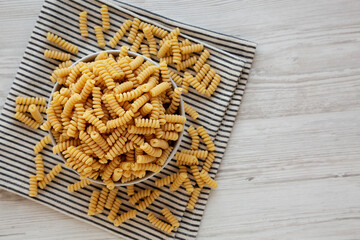 Uncooked Organic Dry Fusilli Pasta in a Bowl, top view. Copy space.