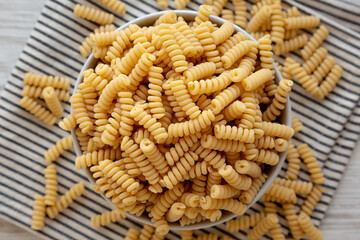Uncooked Organic Dry Fusilli Pasta in a Bowl, top view. Flat lay, overhead, from above.