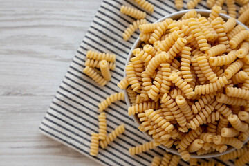 Uncooked Organic Dry Fusilli Pasta in a Bowl, top view. Flat lay, overhead, from above.