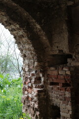 Interior view of a crumbling brick archway at Petrovaradin Fortress in Novi Sad, Serbia. Captured in 2025, showing decay, texture, and contrast between ruin and spring greenery outside.