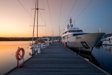 Large luxury Yacht moored at the port during sunset. And soft water on the sea