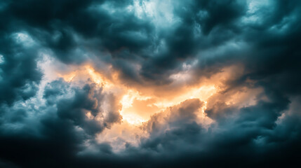 Obraz premium Dark dramatic sky with black storm clouds before rain or snow as abstract background, extreme weather, sun shines through clouds