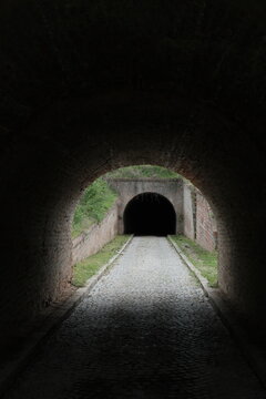 Dark tunnel inside Petrovaradin Fortress, Novi Sad, Serbia, leads into shadow and mystery. Captured in 2025, this historic passage evokes depth, silence, and forgotten history.
