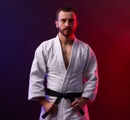 Karate fighter wearing uniform in color lights