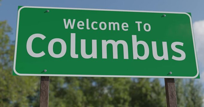 Driving By A Welcome To Columbus, Ohio Green Road Sign Against a Blue Sky and Clouds - United States Capital Series.