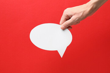 Woman holding blank speech bubble on red background, closeup. Space for text