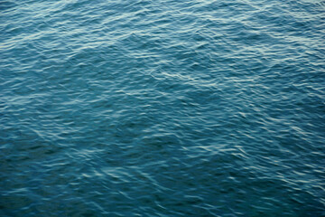 Nature background with sea surface in gradient blue to turquoise colors of small waves on the top